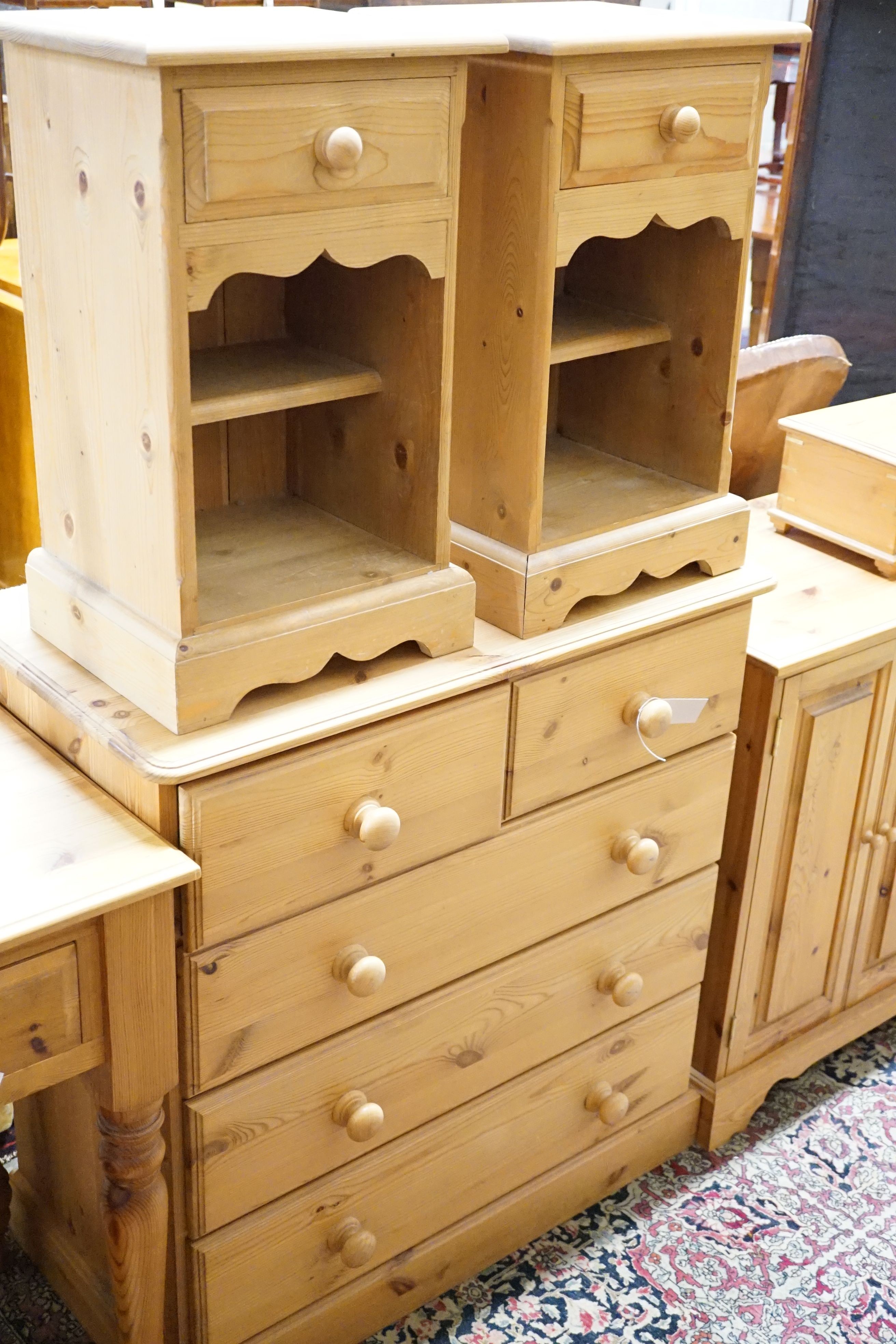 A pine side table, 89cm, a low cabinet, two chests of drawers, a pair of bedside tables, a mirror and jewellery box (8)